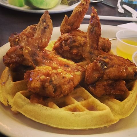 Four chicken wings on top of a Belgian waffle