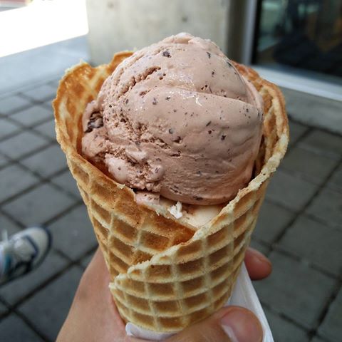 A scoop of chocolate ice cream in a cone